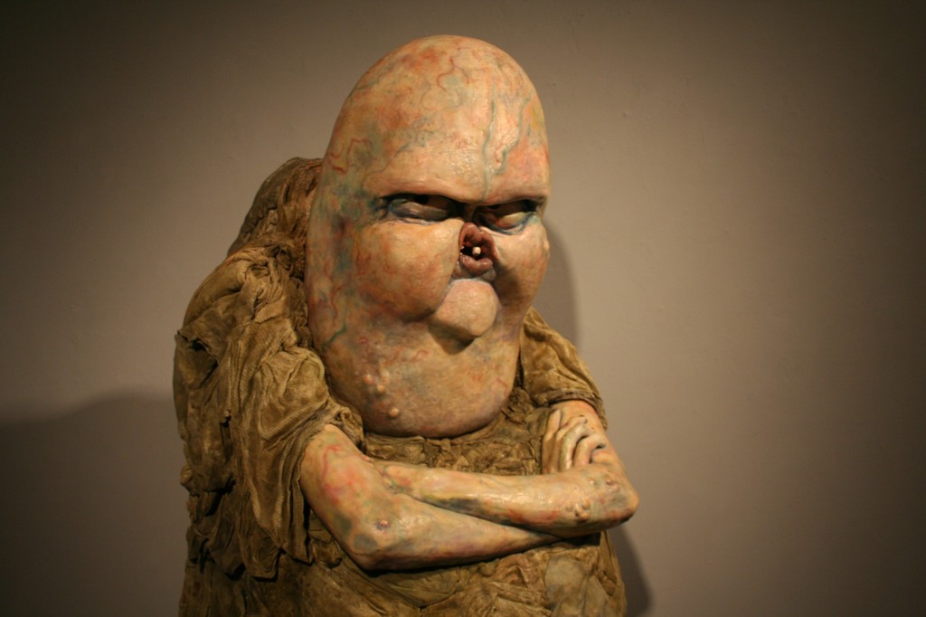 yellowish sculpture of an angry creature