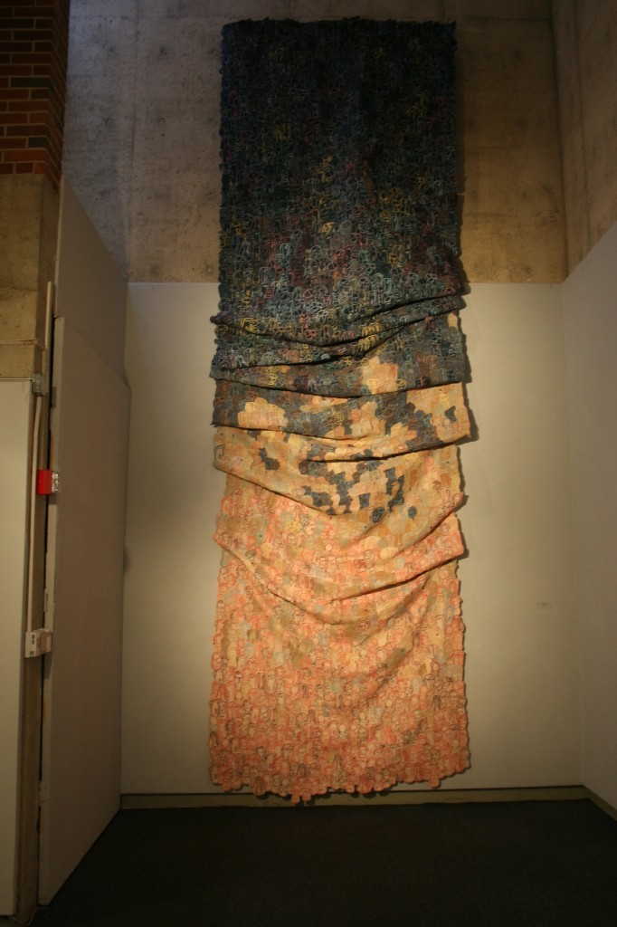 Textile work in a variety of colors up on a gallery wall