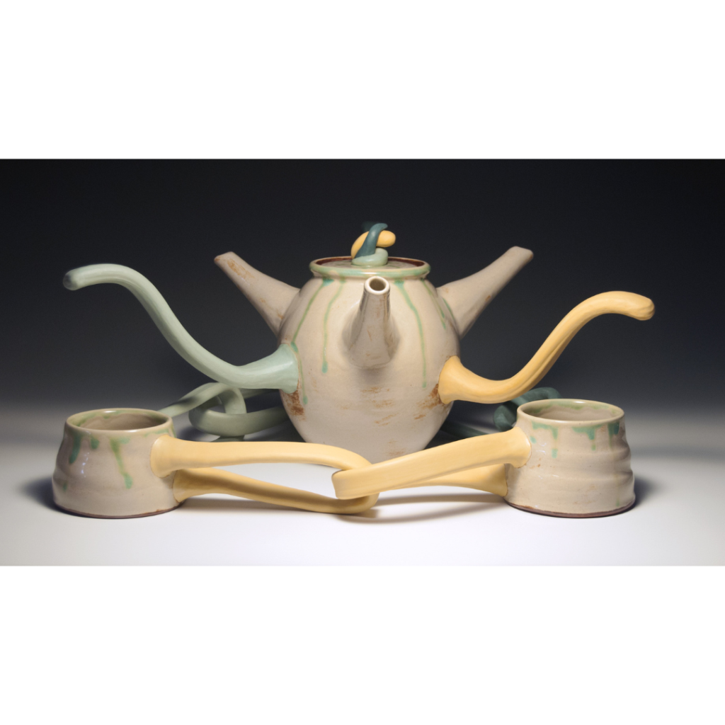 there is a tea pot and two cups sitting on a table
