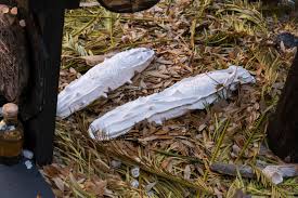 there is a statue of a man holding a knife next to a pile of feathers