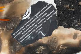 there is a picture of a burnt piece of paper on the ground