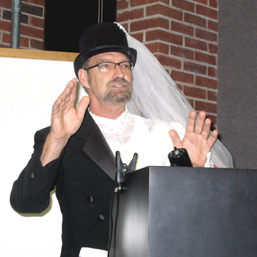 there is a man in a tuxedo giving a speech at a podium
