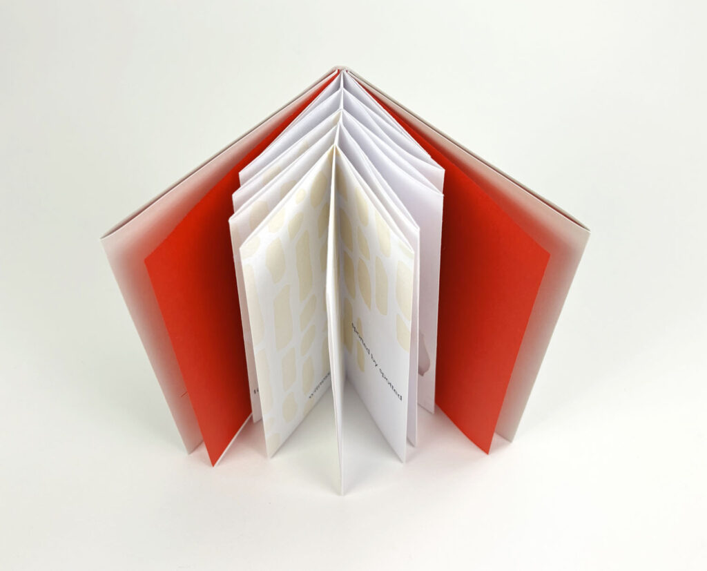 there is an open book with a red cover on a white surface