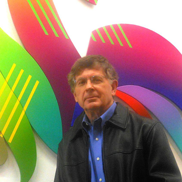 there is a man that is standing in front of a colorful wall