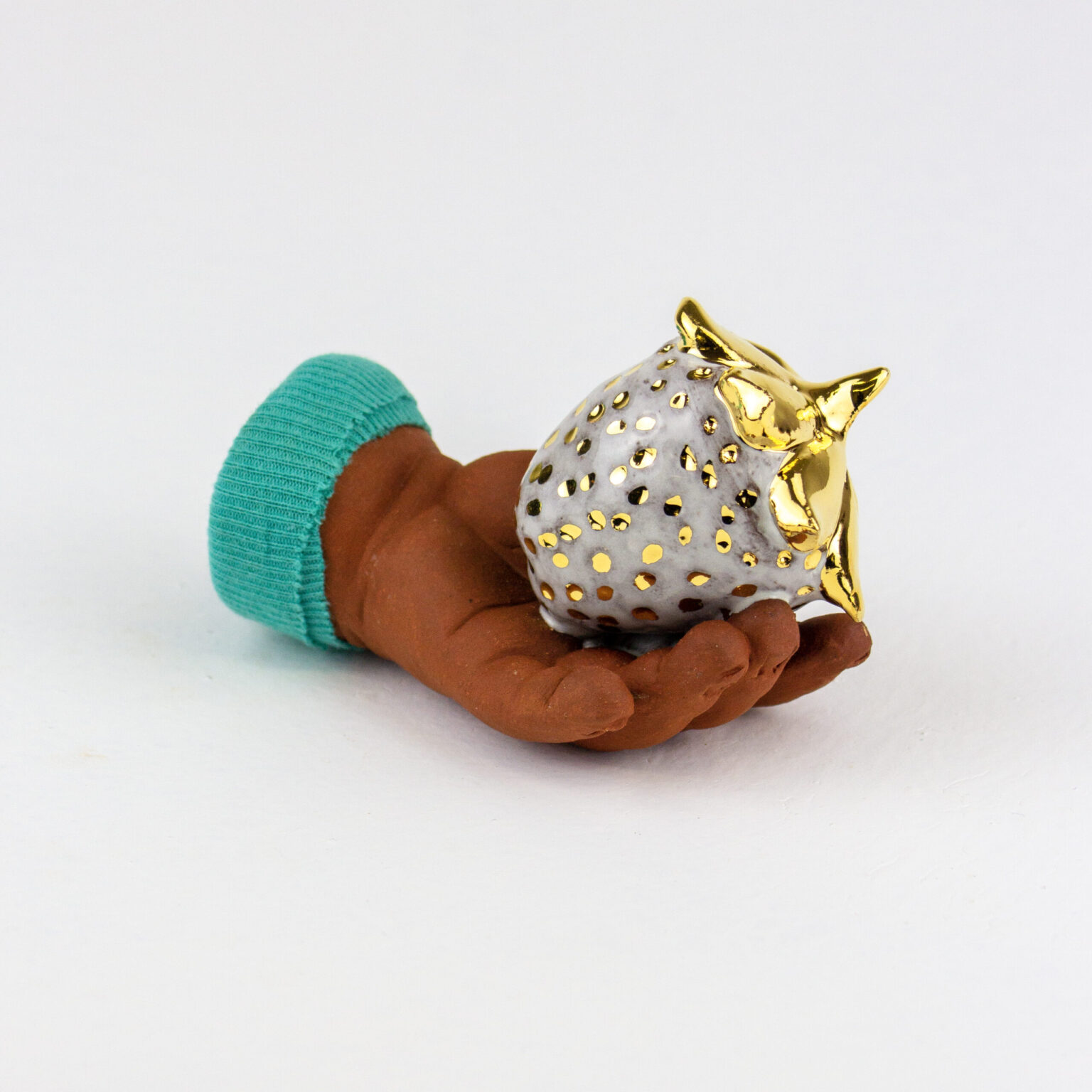 there is a small figurine of a hand holding an owl