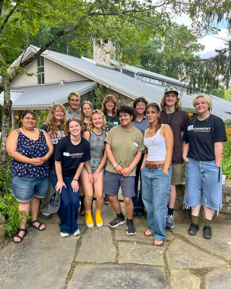 there is a group of people posing for a picture in front of a house