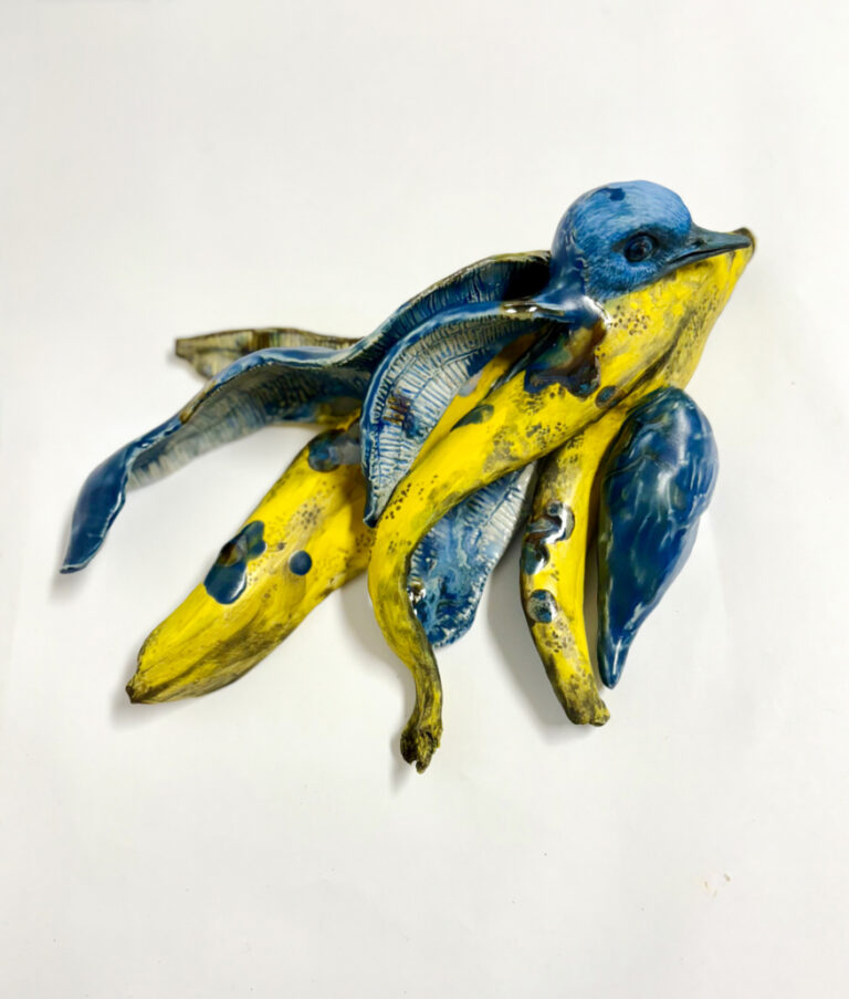 there are three bananas that are painted blue and yellow on a white surface