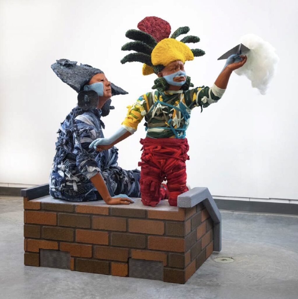there are two statues of a man and a woman sitting on a brick block