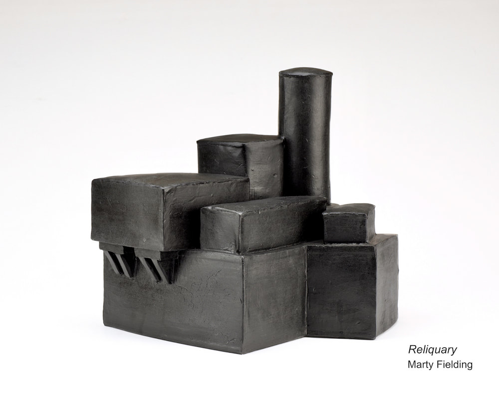 there is a black sculpture made out of concrete blocks on a white surface