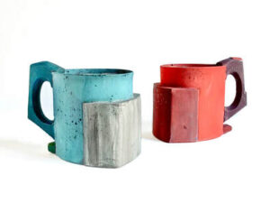 there are two mugs sitting next to each other on a white surface