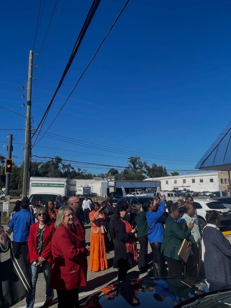 there is a large group of people standing in a parking lot