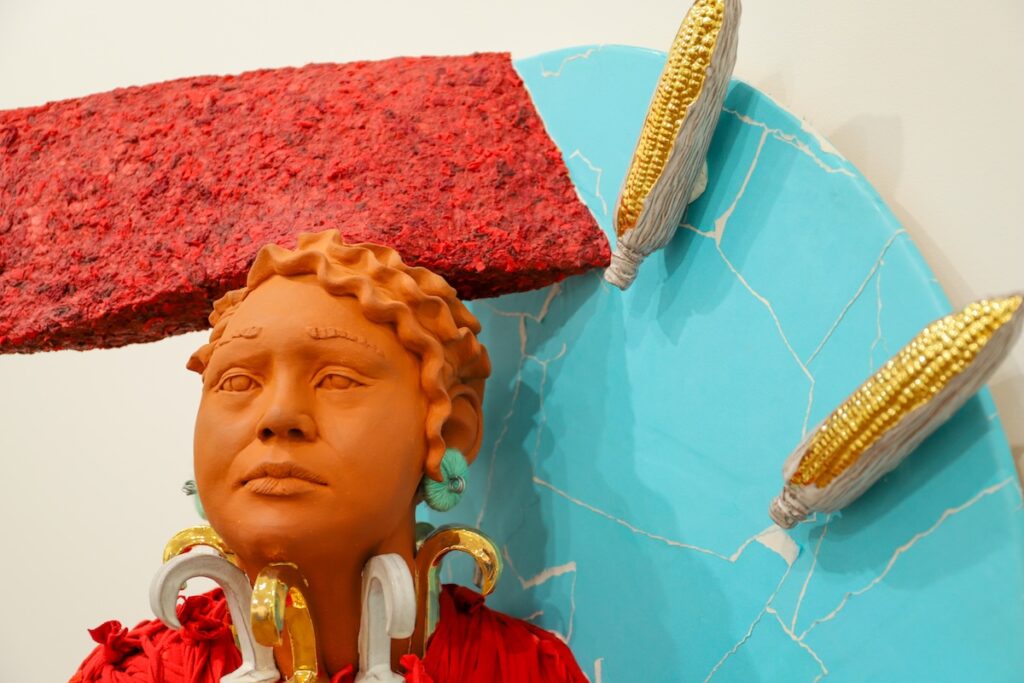 A close-up shot of a red clay sculpture of a person.