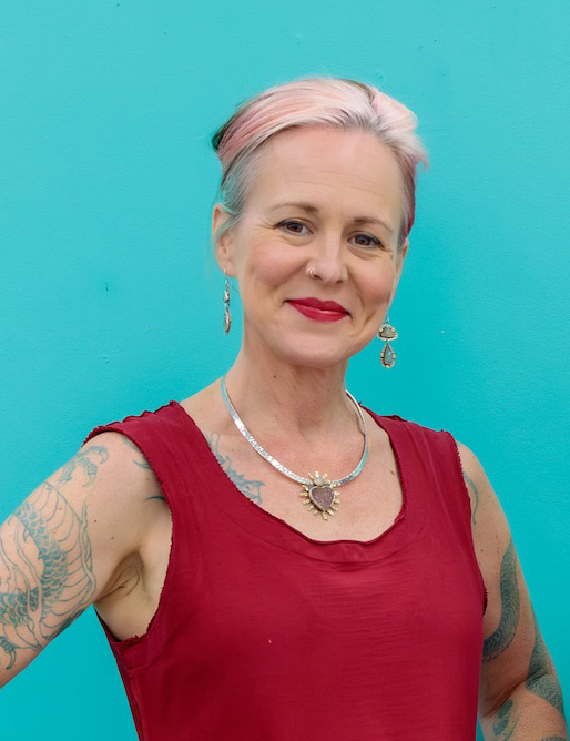A woman in a red dress smiling confidently in front of a blue background